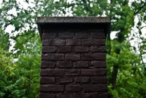 Three Levels of Inspection - Hillsborough NH - Black Moose Chimney dark brown chimney in front of green leaves